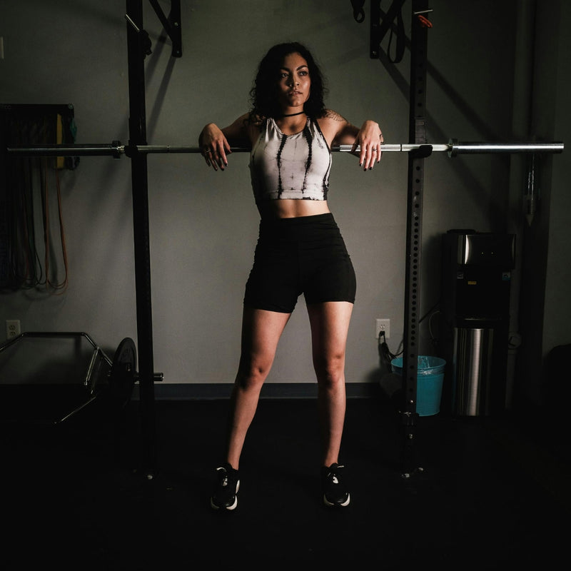 Woman lifting a barbell in a gym setting